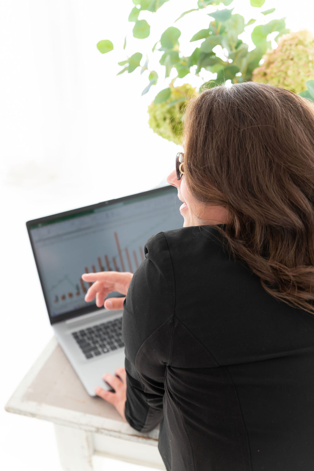 Christina Grootveld bekijkt en analyseert dividendgrafieken op een laptop tijdens persoonlijke begeleiding in Hoog Dividend beleggen.